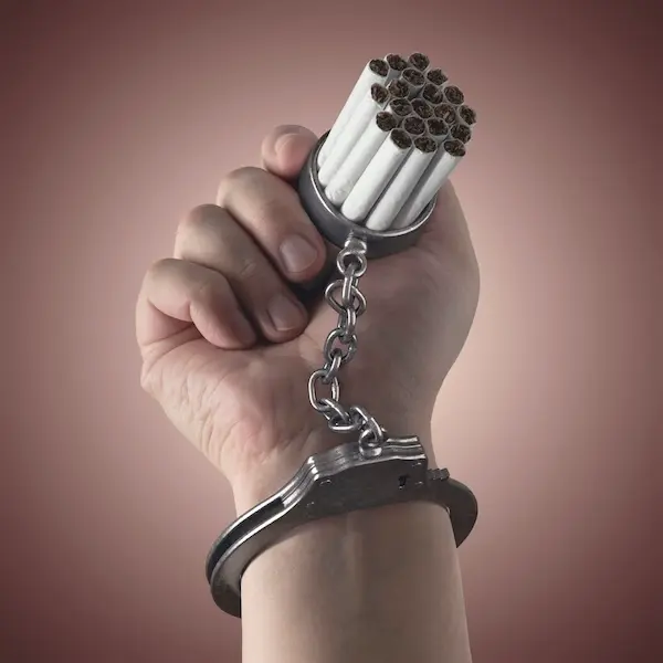 une main menottée à des cigarettes, symbole de l’addiction prise en charge en sophrologie par Cécile Cuby Fontainebleau-Avon