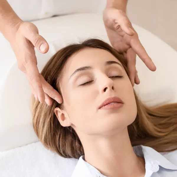 massage des tempes d’une jeune femme lors d’un soin énergétique AETE par Cécile Cuby à Fontainebleau-Avon